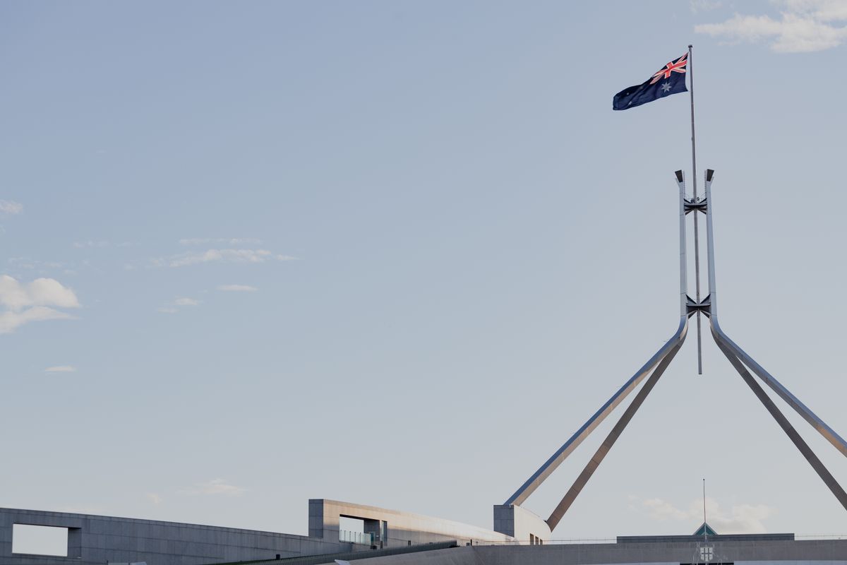 The flag mast of Australia's Parliament House against an open sky.